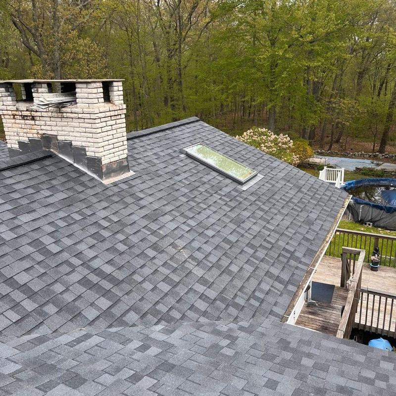 Architectural shingle roof with skylight and brick chimney Architectural shingle roof with skylight and brick chimney