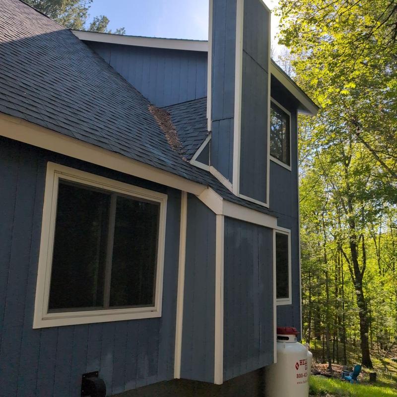 Asphalt shingle roof with debris accumulation near chimney Asphalt shingle roof with debris accumulation near chimney