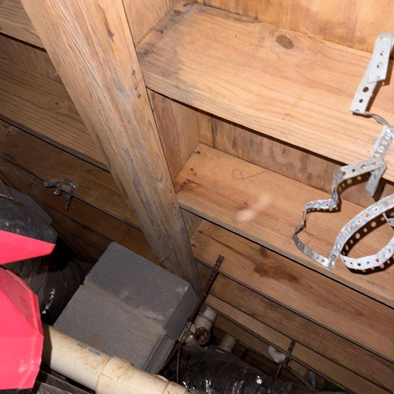 Wooden ceiling joists with metal hanger straps