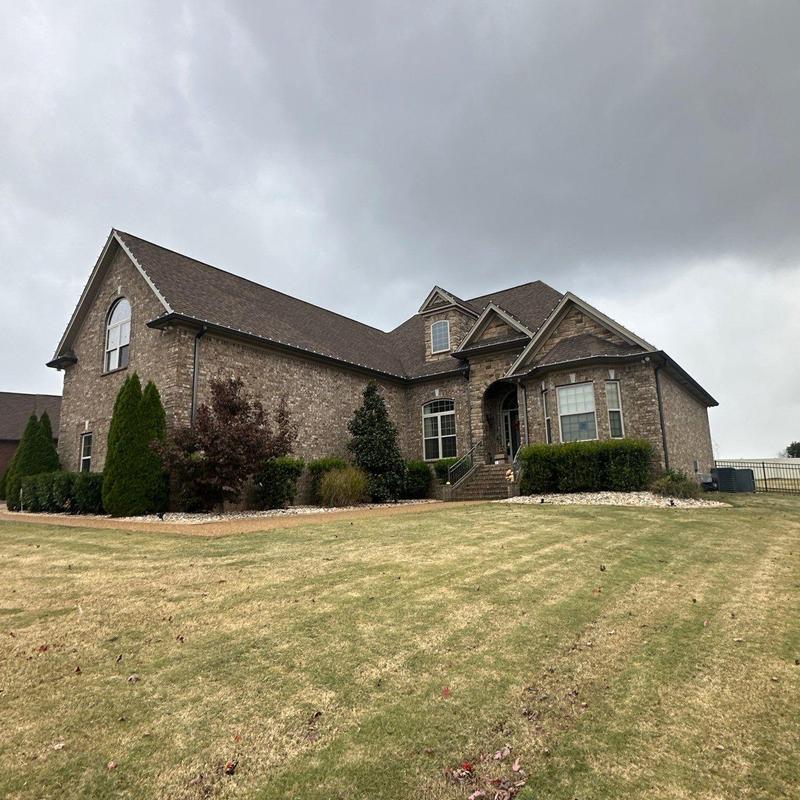 Asphalt shingle roof with hail damage on brick house