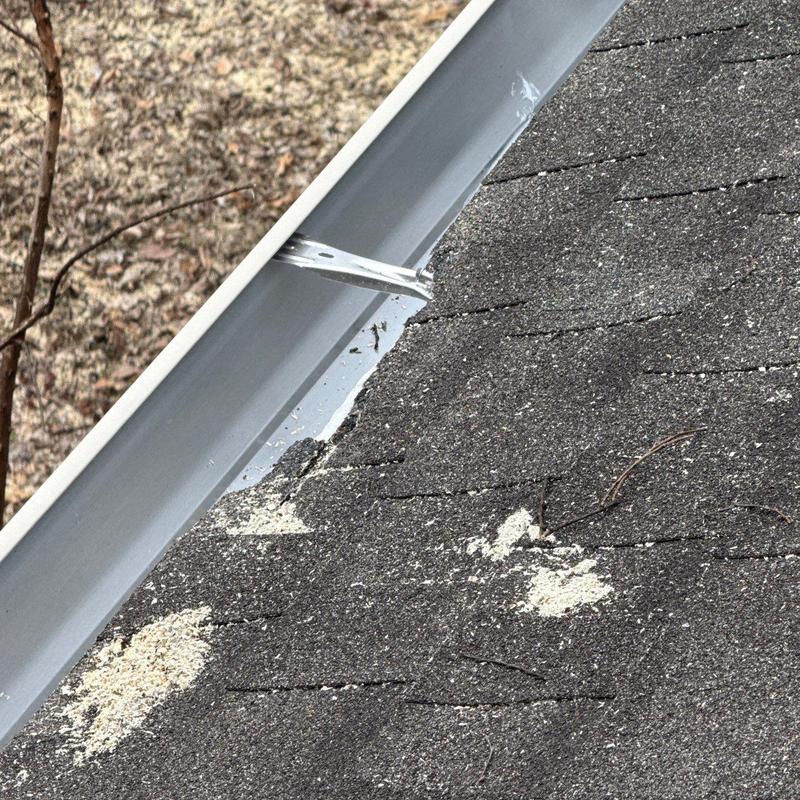 Asphalt shingles with hail damage near gutter system