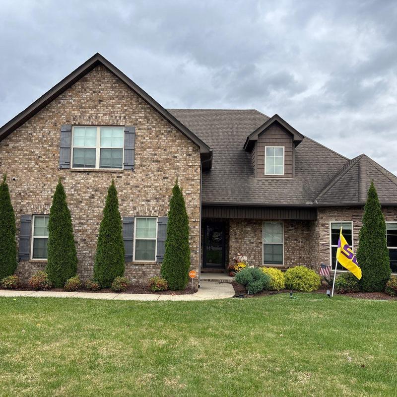Roof shingles with hail damage on brick house