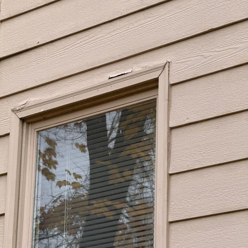 Window frame damage on siding near corner trim