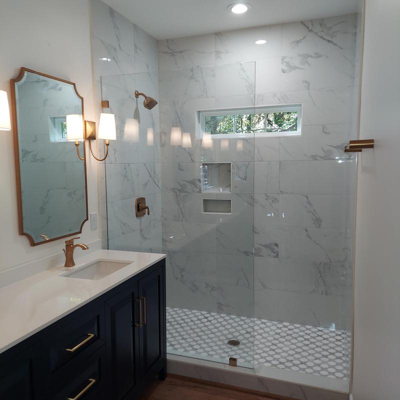 Marble tile walk-in shower with glass door and bronze fixtures Marble tile walk-in shower with glass door and bronze fixtures