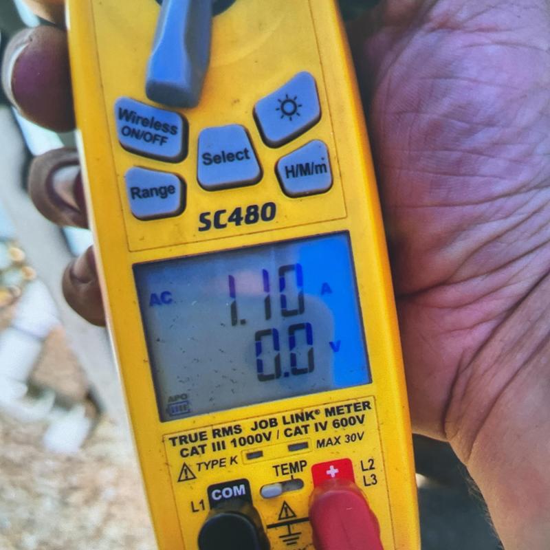 Clamp meter measuring AC current during HVAC maintenance Clamp meter measuring AC current during HVAC maintenance