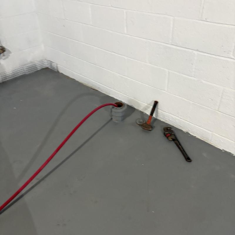 Drain pipe jetting with plumbing tools on floor Drain pipe jetting with plumbing tools on floor