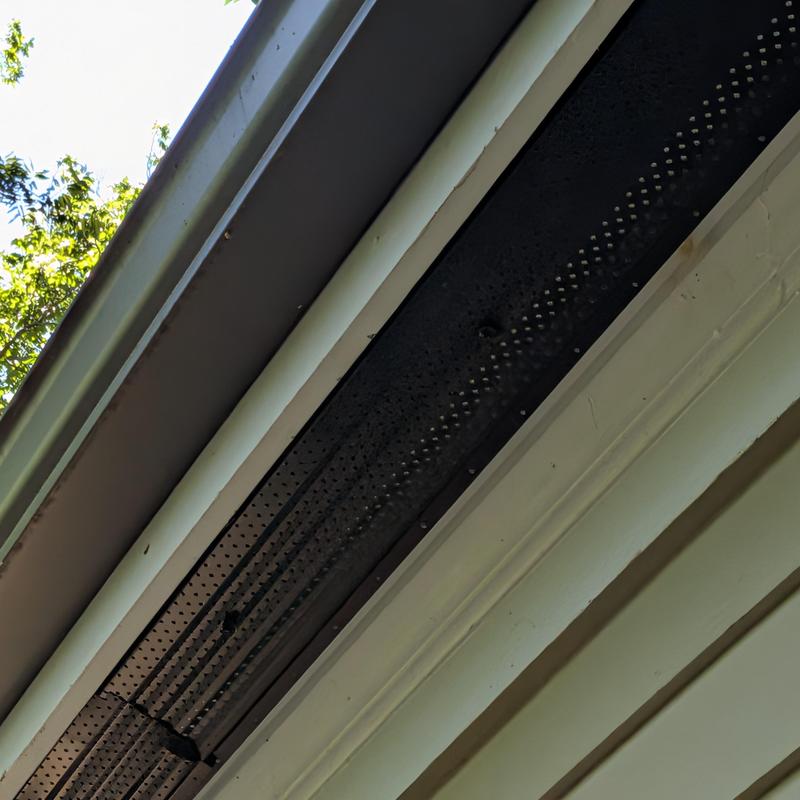 Soffit vent with squirrel damage and repairs