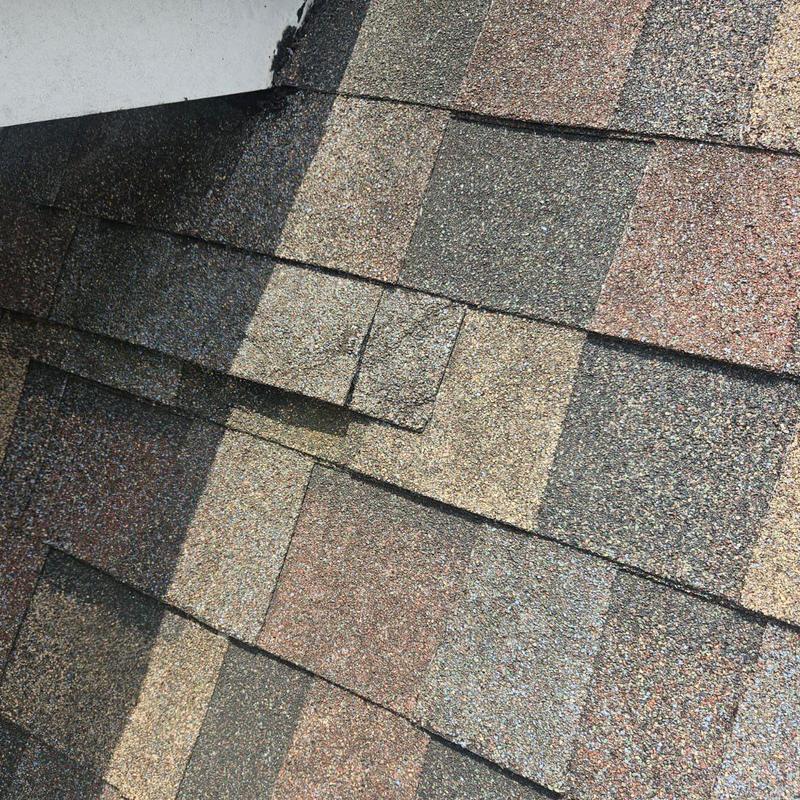Asphalt roof shingles with a cracked shingle close-up Asphalt roof shingles with a cracked shingle close-up