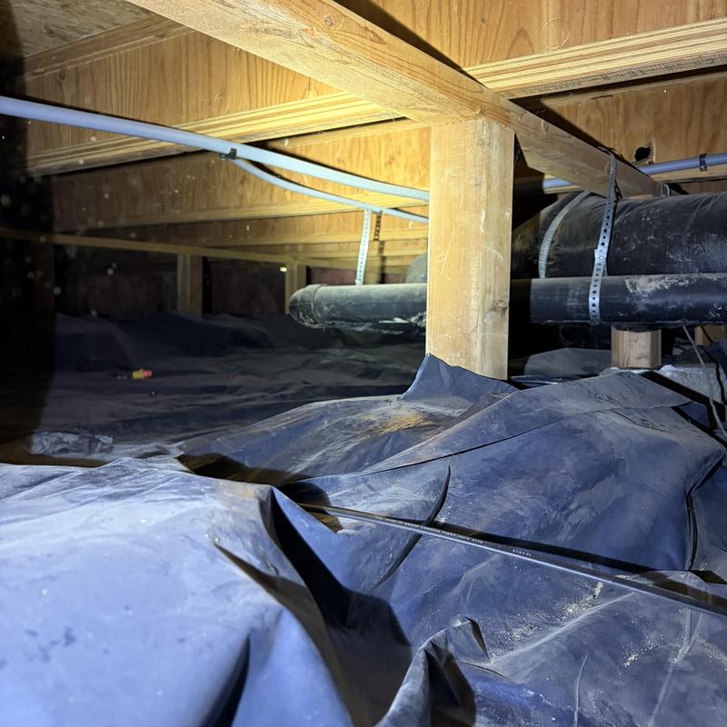 Crawl space moisture barrier with plumbing pipes above