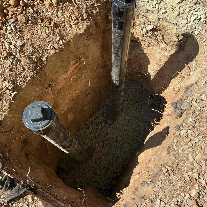 Sewer piping excavation with vertical pipes in trench