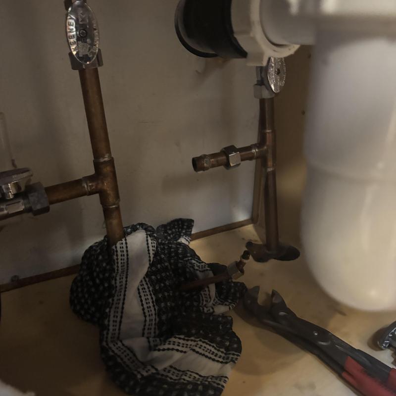 Angle stop valve replacement under sink with wrench and rag