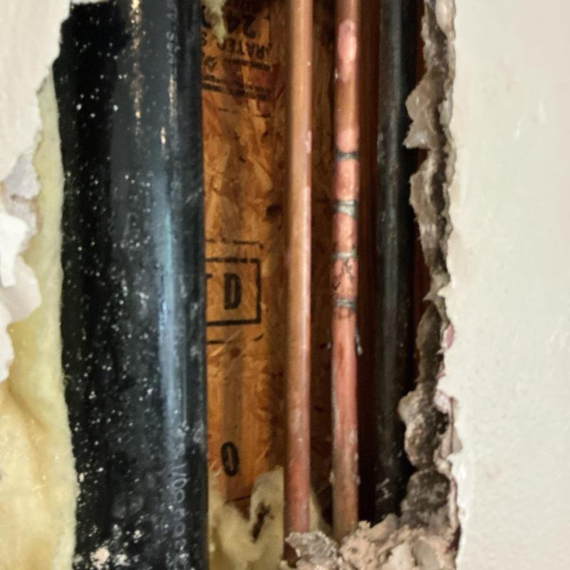Copper waterline pipes inside wall cavity with insulation