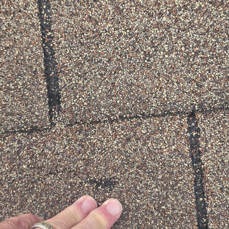 Asphalt roof shingles with hail damage close-up