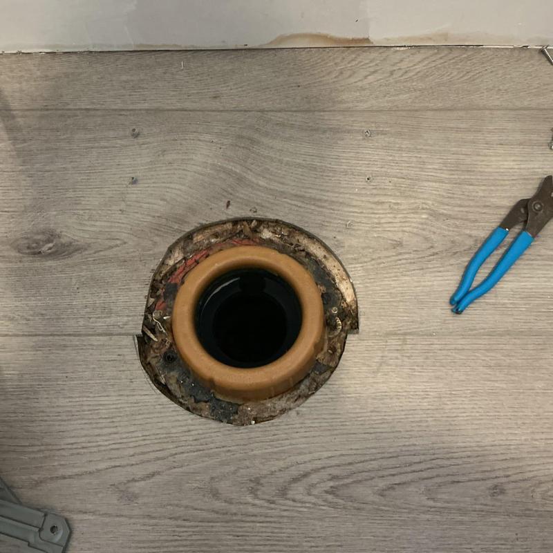 Toilet flange with new wax ring and pliers nearby