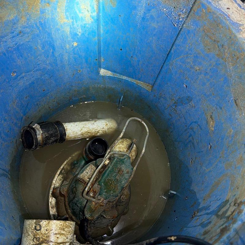 Sump pump basin with old pump and piping Sump pump basin with old pump and piping