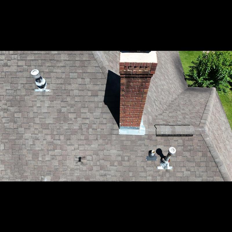 Asphalt shingle roof with brick chimney and vent pipes