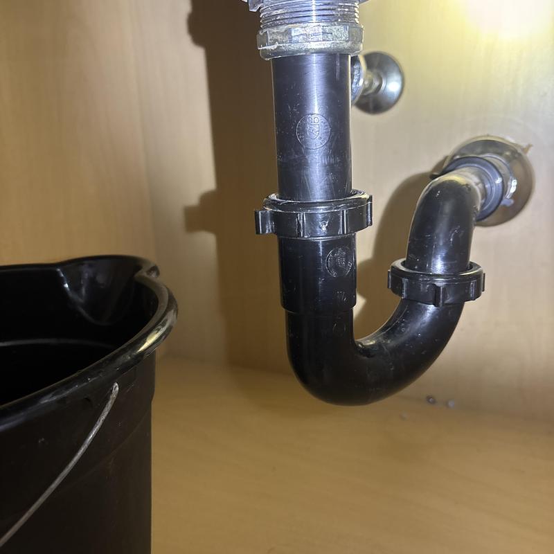 Sink drain trap pipe with bucket under cabinet Sink drain trap pipe with bucket under cabinet