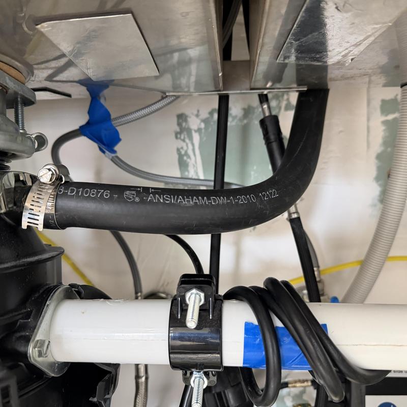 Dishwasher drain hose and plumbing connections under sink