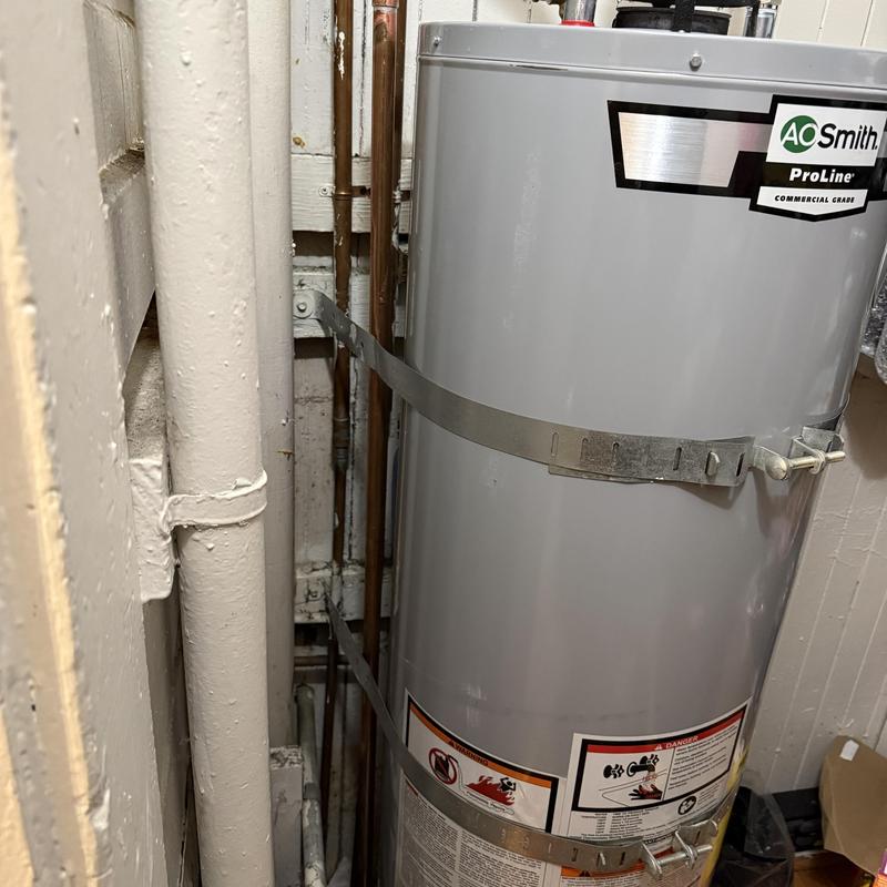 Water heater tank with securing straps and piping Water heater tank with securing straps and piping