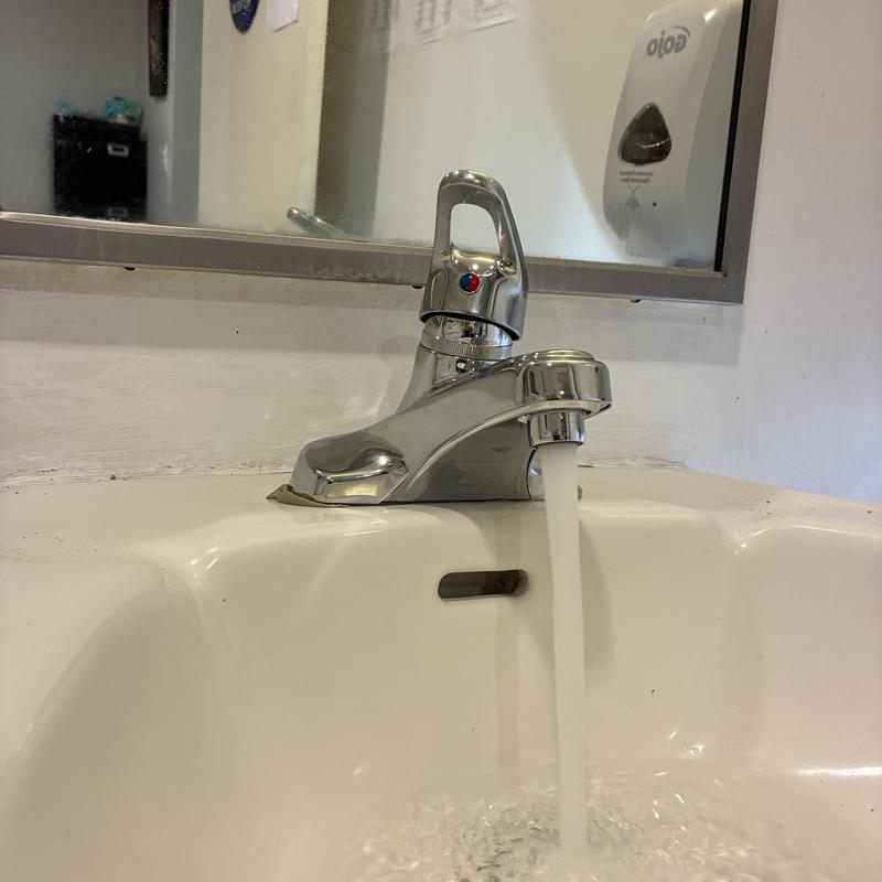 Bathroom sink faucet with running water flow Bathroom sink faucet with running water flow