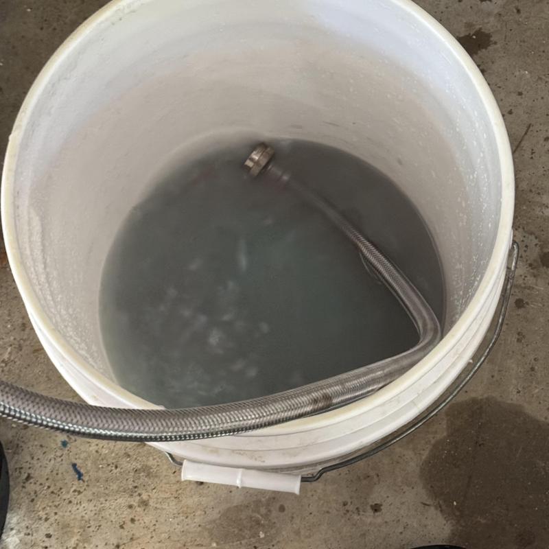 Rinnai tankless water heater flushing hose in bucket Rinnai tankless water heater flushing hose in bucket