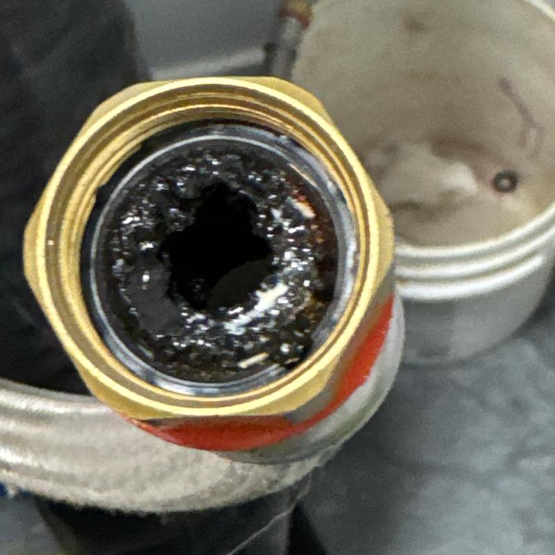 Electric tankless water heater pipe clogged with black debris