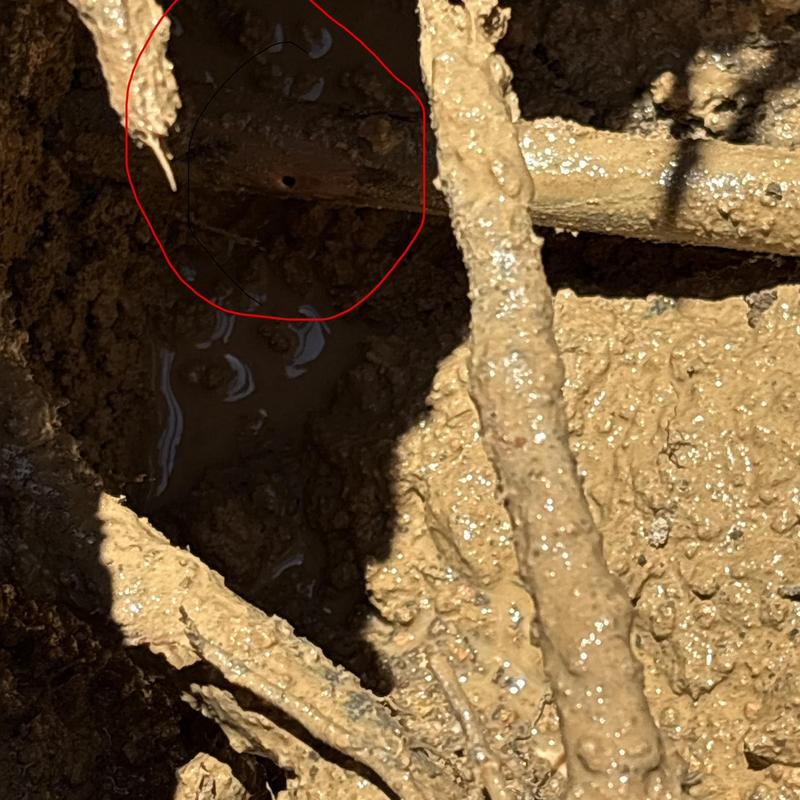 Copper main waterline in muddy excavation site Copper main waterline in muddy excavation site