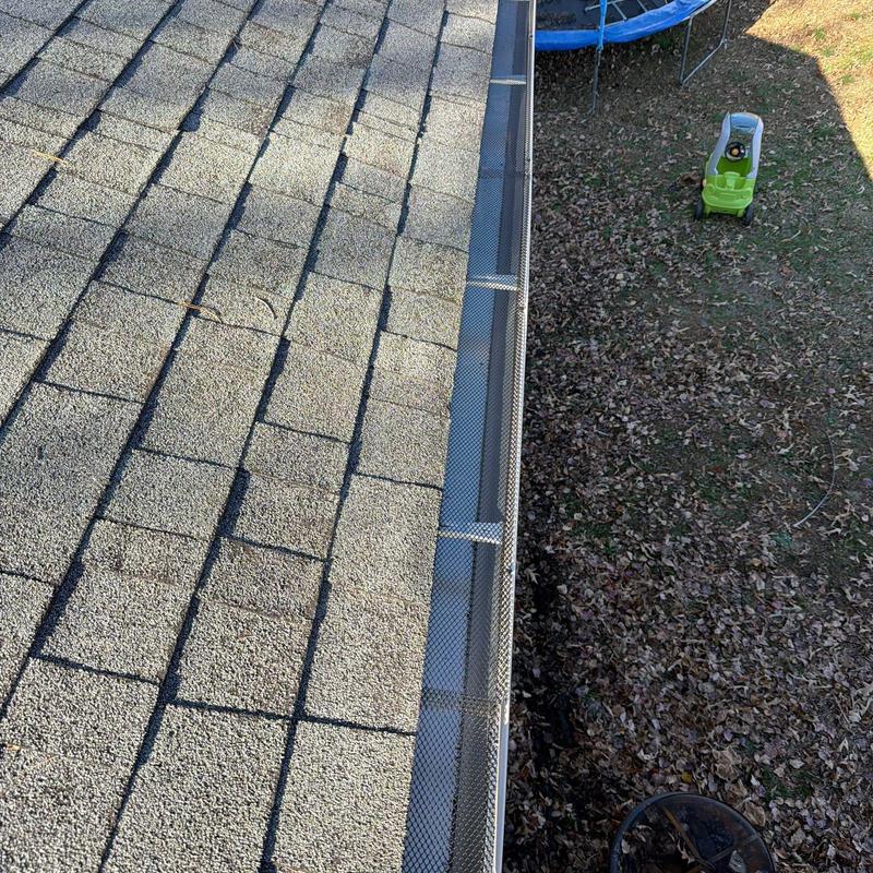 Gutter leaf guard installation on residential roof edge