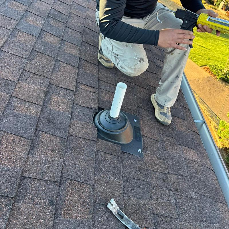Roof vent flashing on asphalt shingle roof with sealant gun