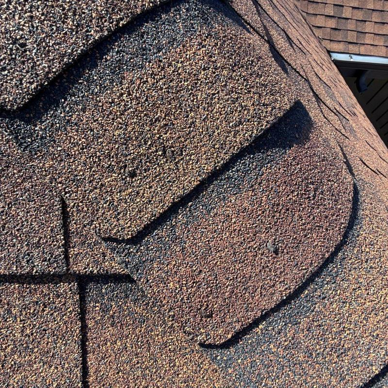 Asphalt shingles with visible hail impact damage