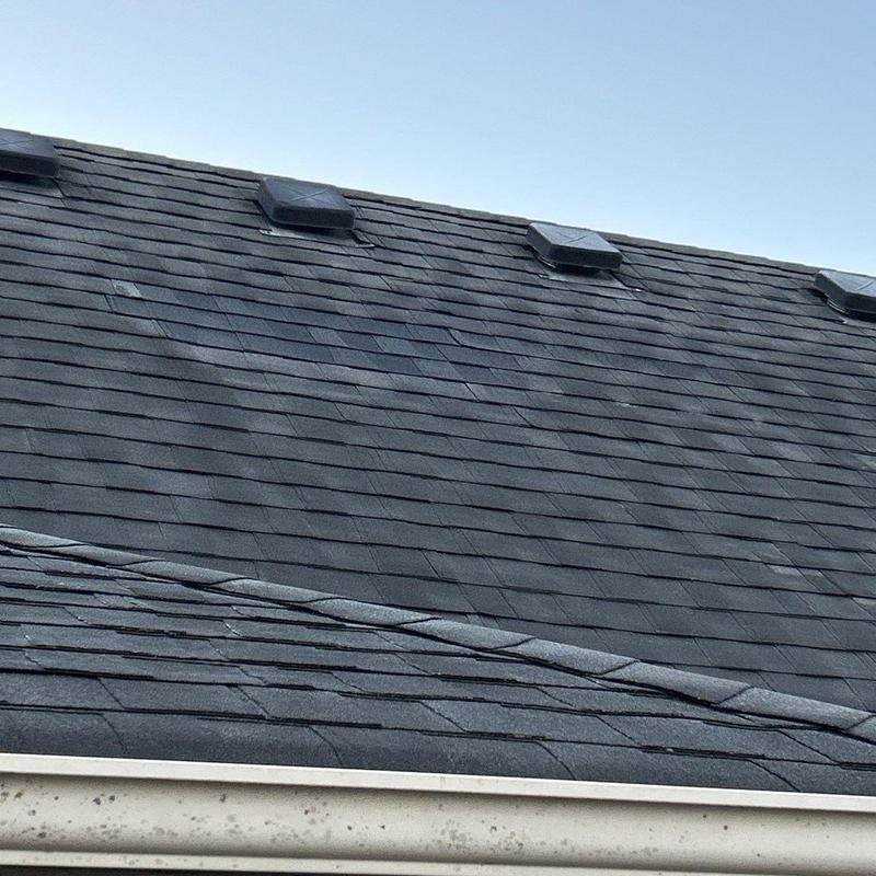 Asphalt shingle roof with hail damage and ventilation units