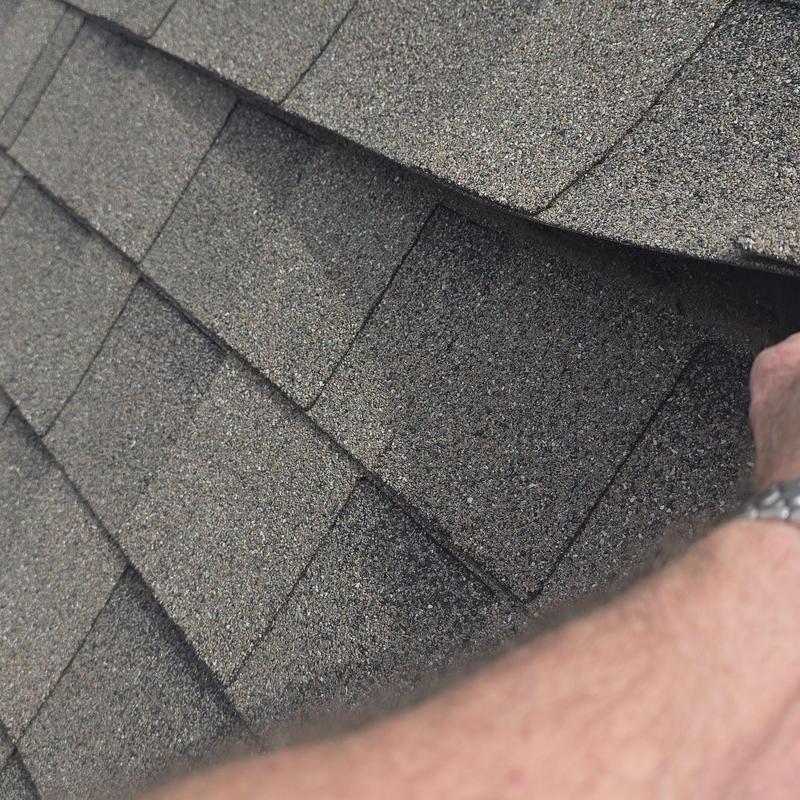 Asphalt roof shingles showing hail damage close-up