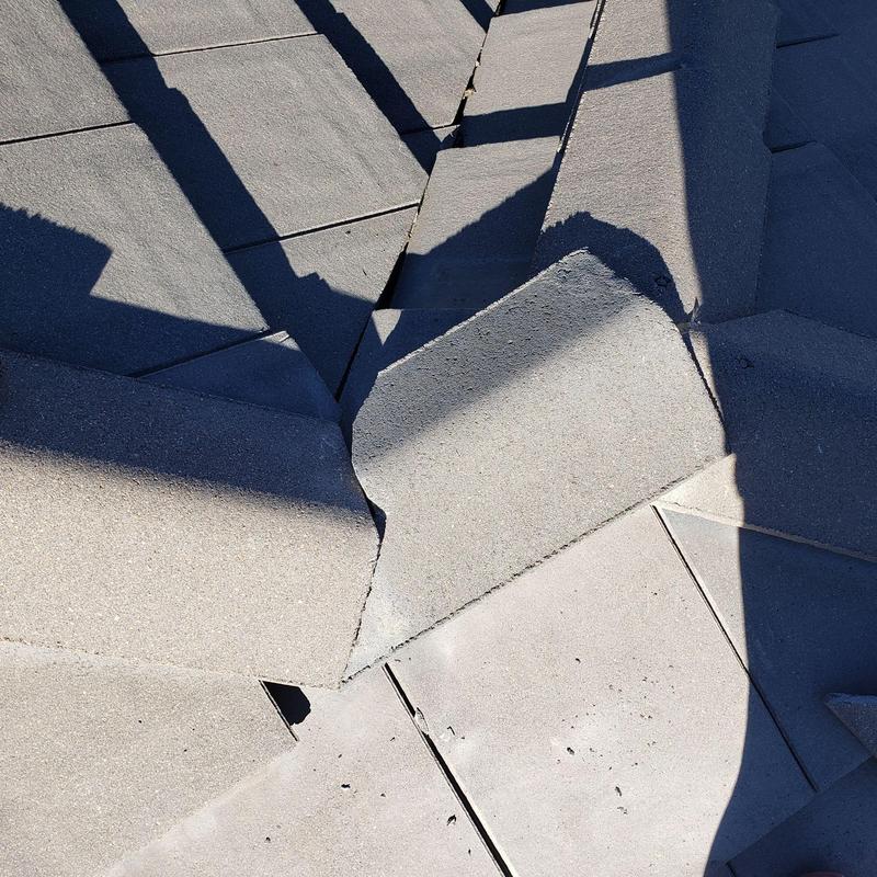 Tile roof with lifted and cracked tiles under sunlight shadows Tile roof with lifted and cracked tiles under sunlight shadows