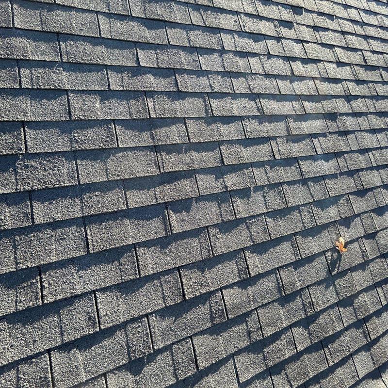 Asphalt shingles with visible hail damage on roof