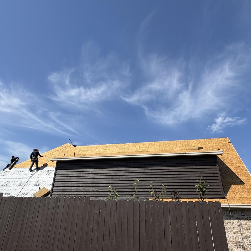 Roof decking installation on residential home with workers