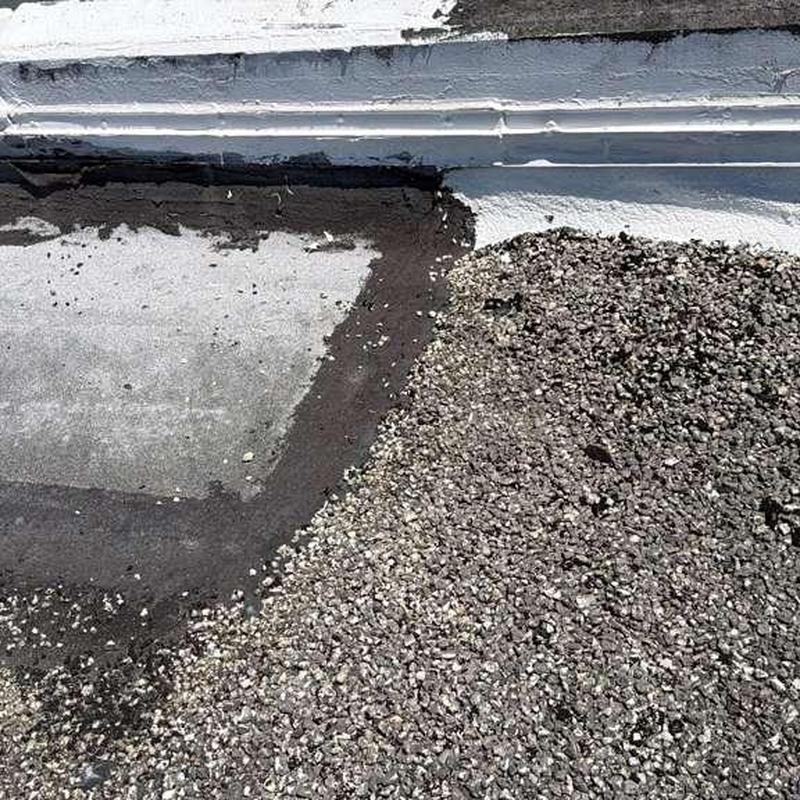 Gravel flat roof with patch repair area near edge Gravel flat roof with patch repair area near edge