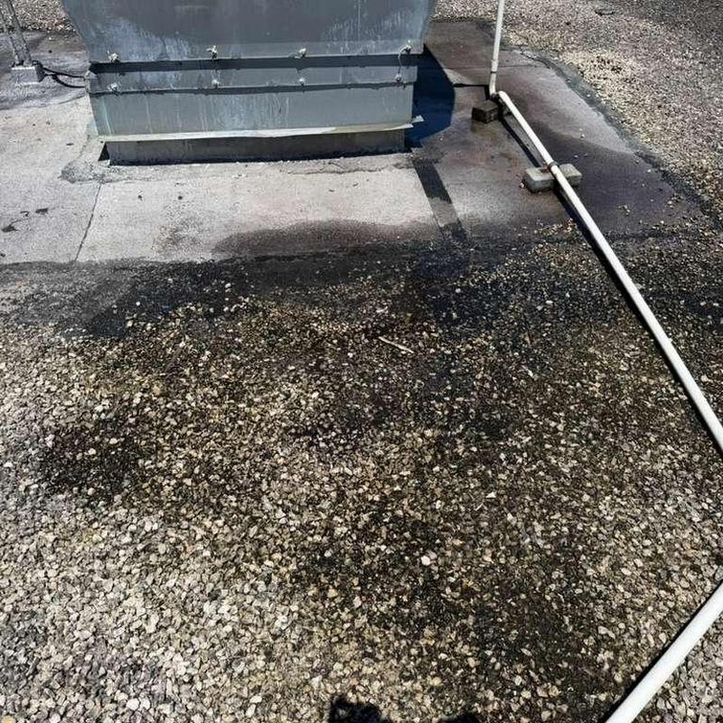 Gravel flat roof with stains near rooftop vent Gravel flat roof with stains near rooftop vent