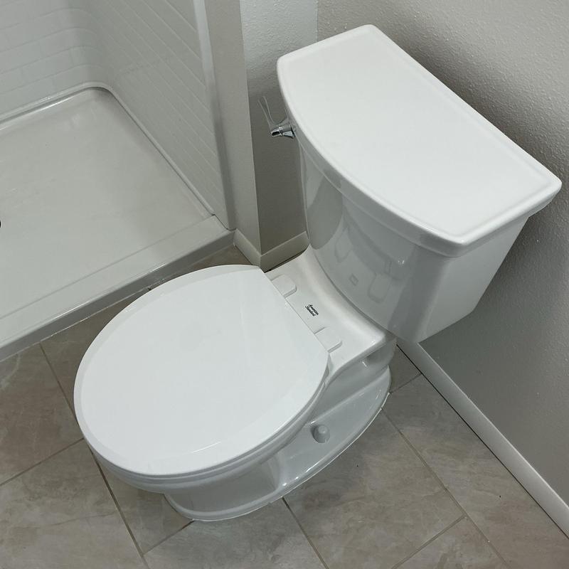 Toilet installation in bathroom corner near shower
