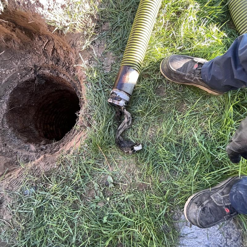 Septic tank pump-out hose and open tank pit