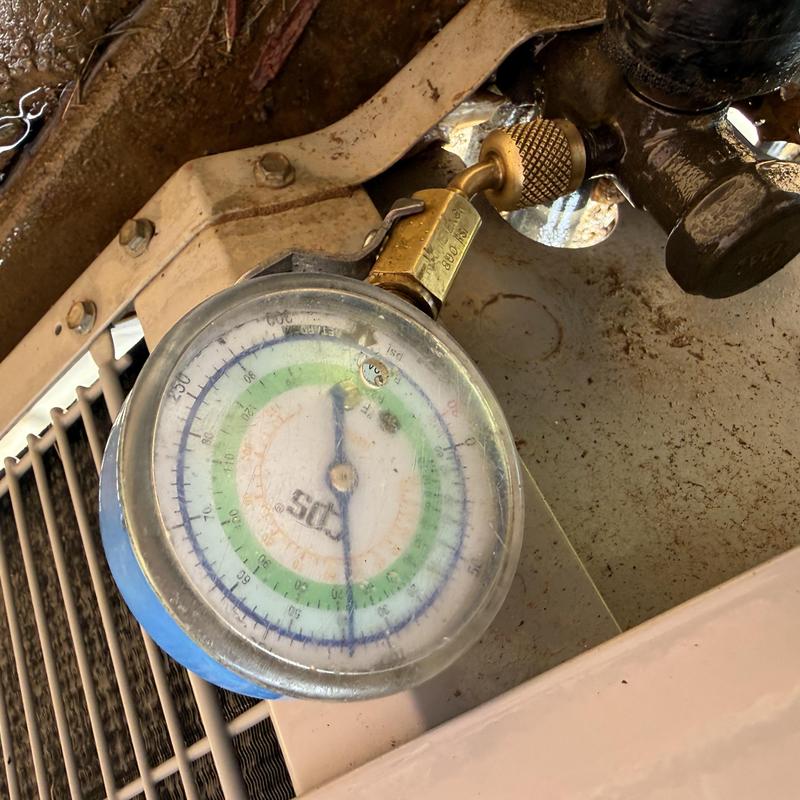 Refrigerant gauge attached to outdoor AC condenser unit Refrigerant gauge attached to outdoor AC condenser unit