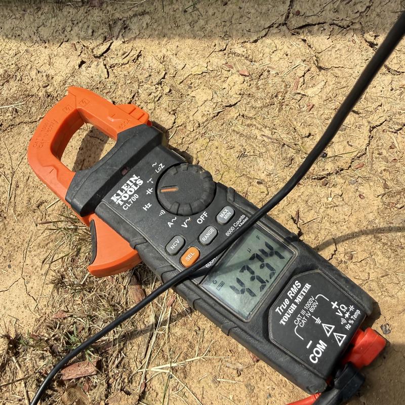 Electrical clamp meter measuring current on dry ground Electrical clamp meter measuring current on dry ground