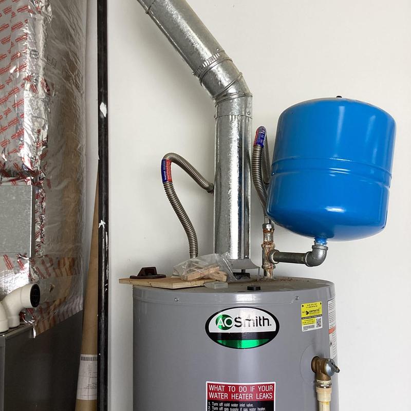 Water heater with blue expansion tank and vent pipe
