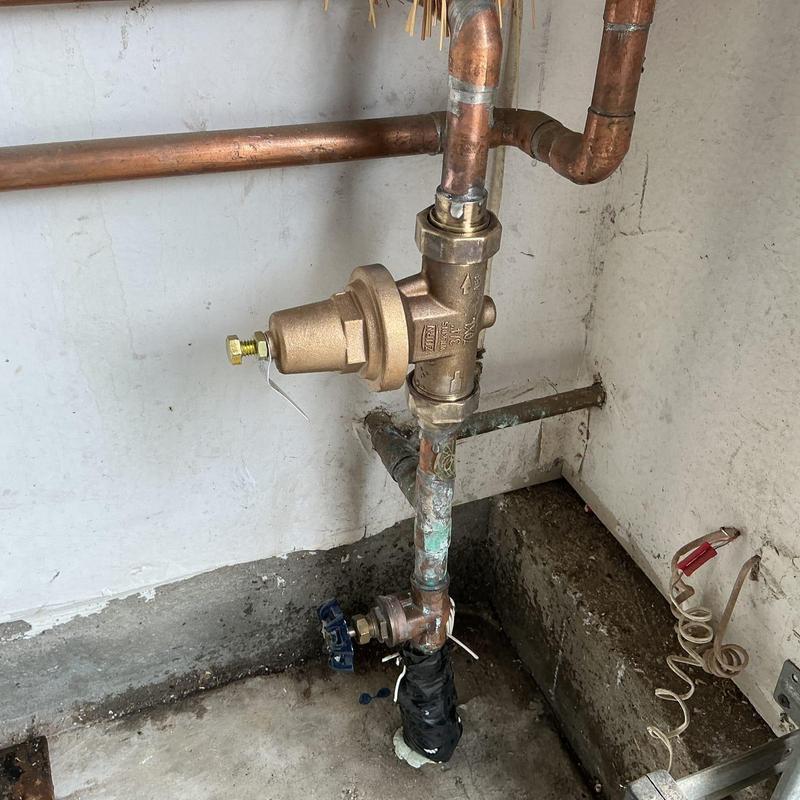Pressure regulator installation with copper piping in corner