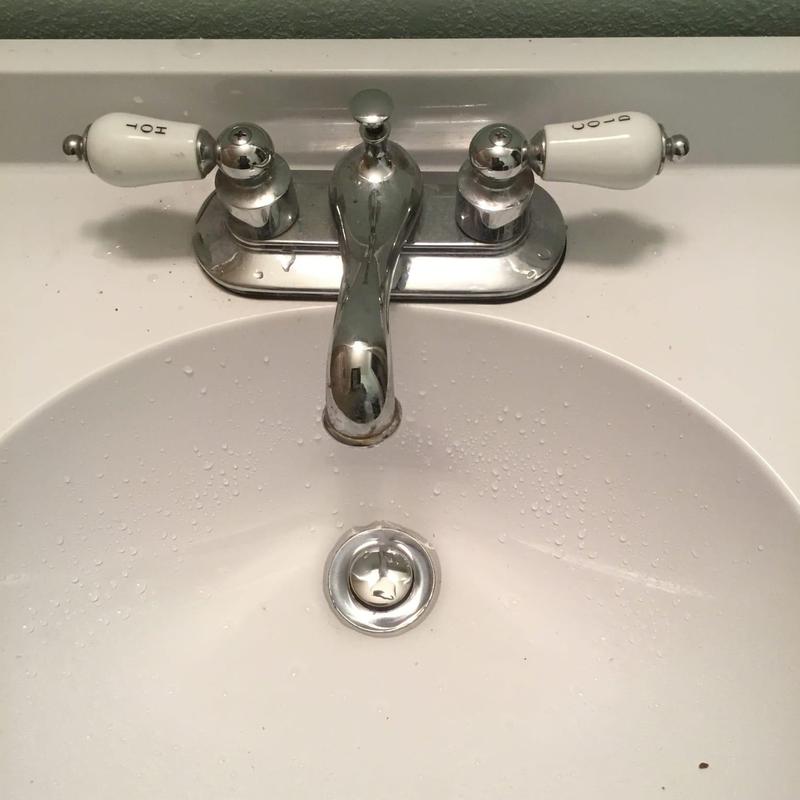 Bathroom faucet with dual handles and water droplets