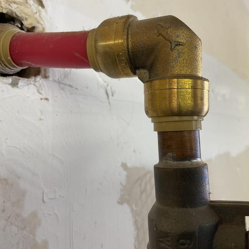 Copper water line elbow with brass fitting and PEX pipe