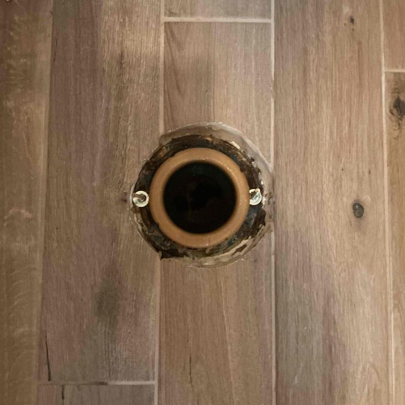 Toilet flange on wood-look tile floor, no toilet installed