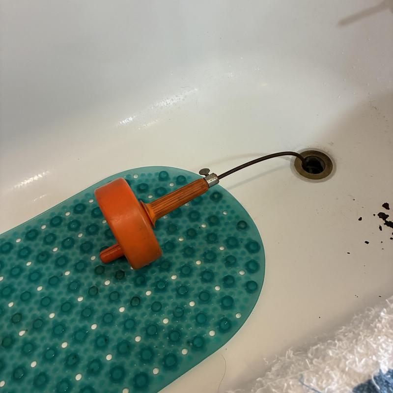 Bathtub drain clog with plumbing snake in tub Bathtub drain clog with plumbing snake in tub