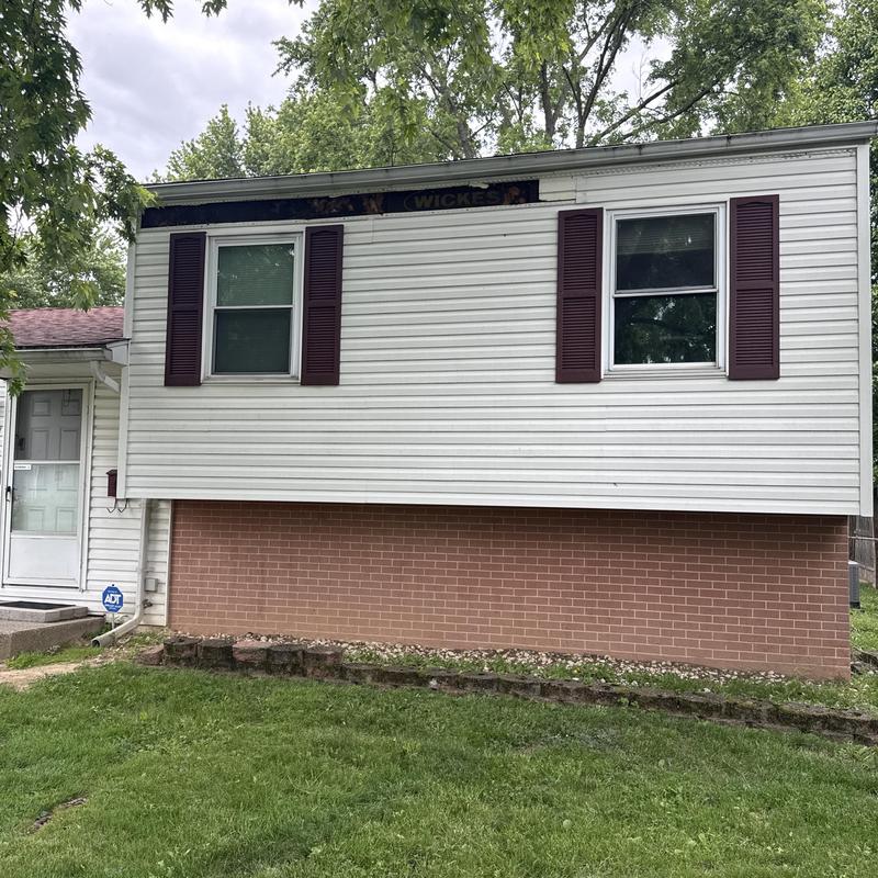 Vinyl siding with storm damage on house exterior