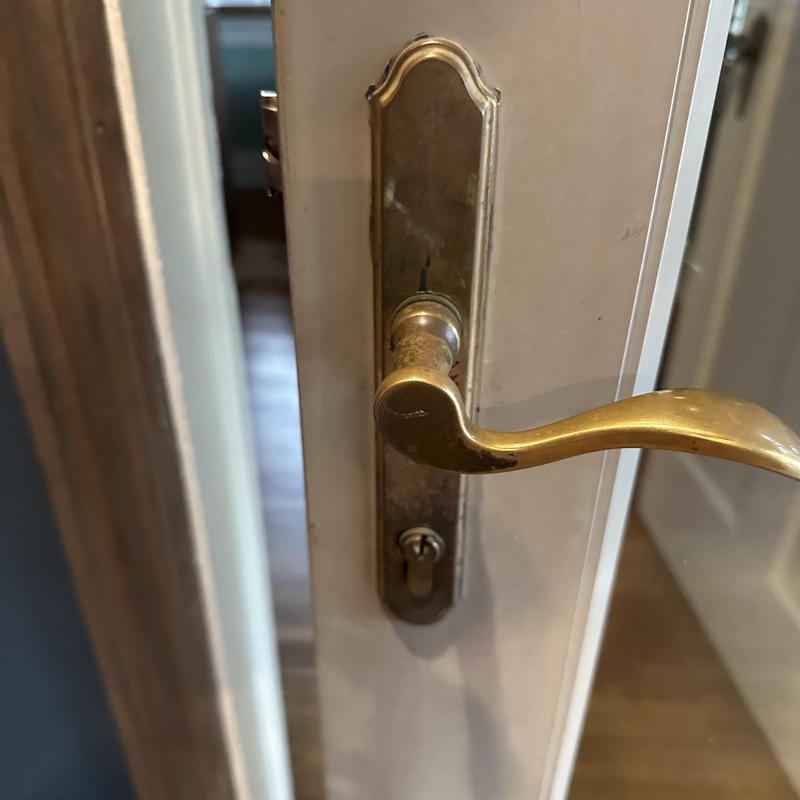 Multi point door lock with brass handle on white door