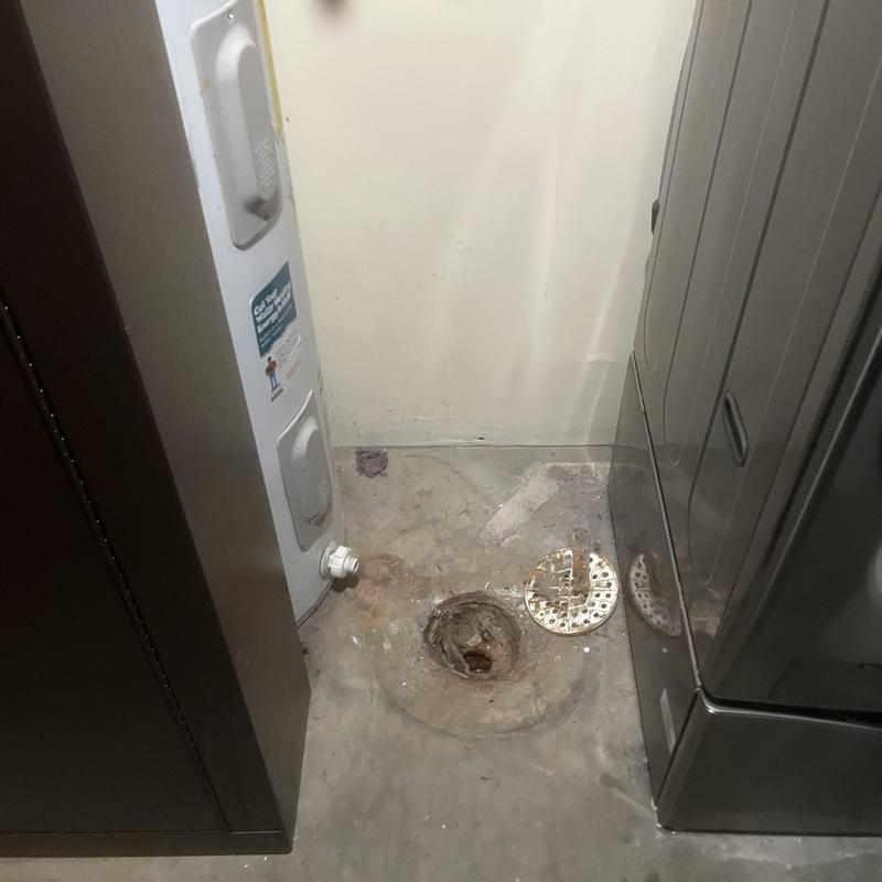 Sewer line opening in laundry room floor near appliances